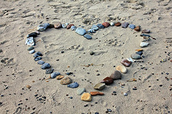 Herz aus Kieselsteinen im Sand